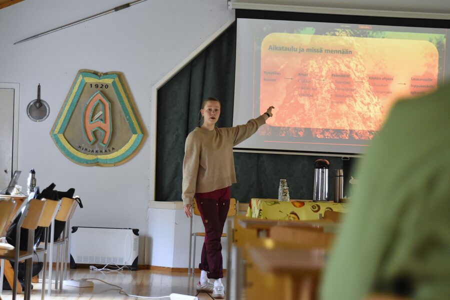 Koponen pitää esitystä yleisön edessä.