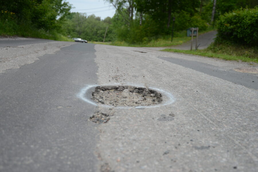 Kuva isosta reiästä tiellä.