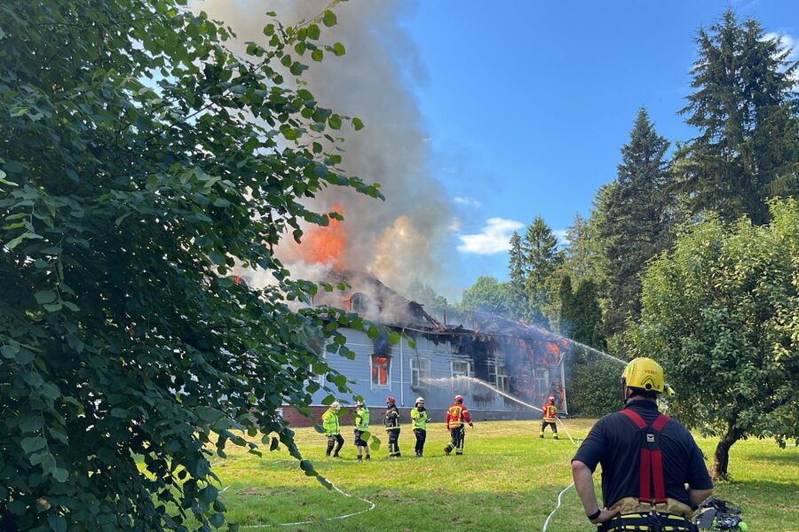 Kuvassa näkyy palava talo ja sen sammutustyöt.