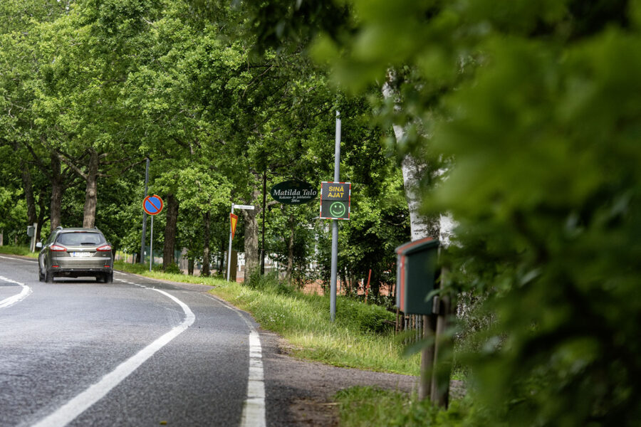 Kuvassa näkyy nopeusmittari tiellä. Mittarissa on hymynaama.